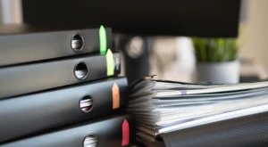 Folders and binders containing organized administrative documentation on a shelf.