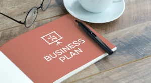 Business plan aperto su una scrivania, con grafici finanziari e calcolatrice.