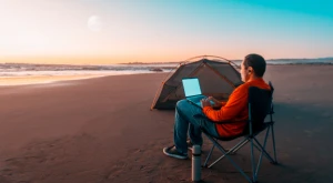 Nomade digitale che lavora al computer portatile in spiaggia