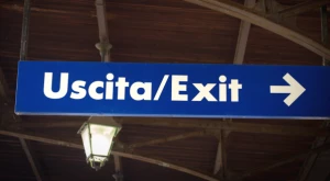 Letrero de aeropuerto con indicaciones de "Entrada" y "Salida"