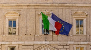 Las banderas de Italia y de la Unión Europea colocadas juntas, en representación de la coordinación entre la legislación nacional y las políticas migratorias europeas sobre el permiso único de residencia y trabajo.