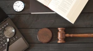 A laptop displaying digital documents and a judge’s gavel resting on a desk, symbolizing the legal and parliamentary debate on Italian citizenship.