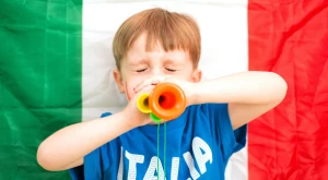 Bambino davanti alla bandiera italiana, simbolo della cittadinanza italiana per discendenza.