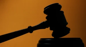 Martelletto del giudice su una superficie in legno, simbolo della giustizia e delle decisioni giudiziarie.