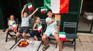 Niños reunidos con una bandera italiana