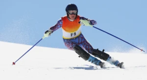 Esquiador profesional compitiendo en un evento internacional de deportes de invierno.