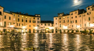 Plaza italiana de noche con edificios históricos iluminados.