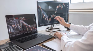 Persona revisando gráficos de inversión en un portátil, simbolizando la planificación financiera para la Visa de Inversor de Italia