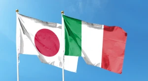 Banderas de Japón e Italia colocadas una junto a la otra, símbolo de cooperación y del acuerdo de Vacaciones y Trabajo entre ambos países.