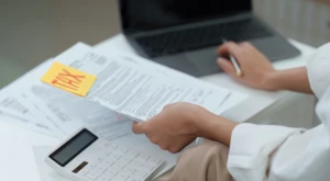 Persona calculando impuestos con documentos y calculadora