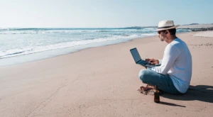 Digital nomad working on a laptop on the beach