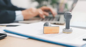 Person at a desk stamping official documents.